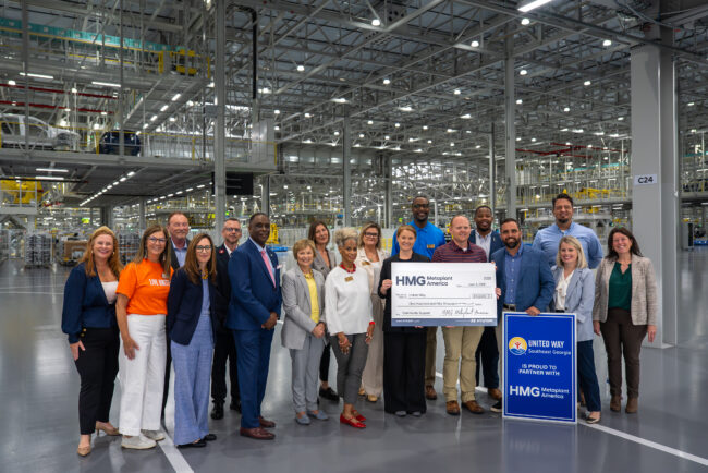 Group of people holding a large check